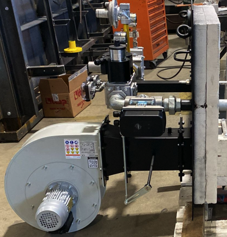 Industrial equipment with valves and a motor on a workshop floor.